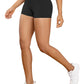 Person wearing black high-waisted shorts and white sneakers on a neutral background
