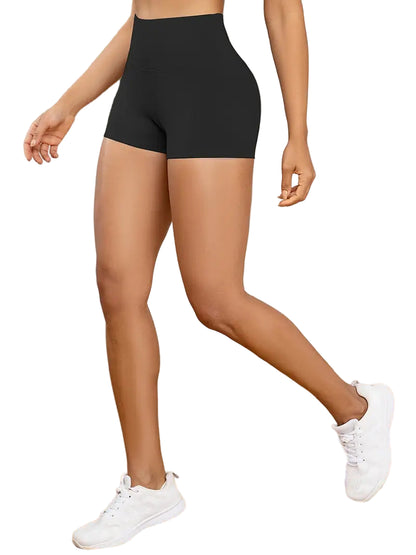 Person wearing black high-waisted shorts and white sneakers on a neutral background