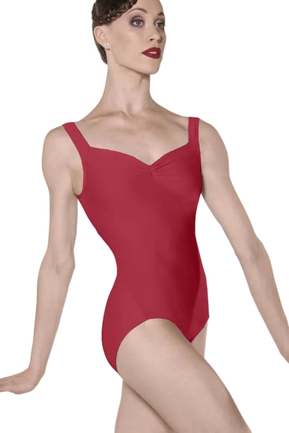 A woman modeling a red sleeveless leotard with a sweetheart neckline and wide shoulder straps, photographed against a clean light gray studio background.