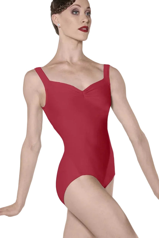 A woman modeling a red sleeveless leotard with a sweetheart neckline and wide shoulder straps, photographed against a clean light gray studio background.